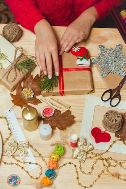 Mão de mulher criando decorações de Natal