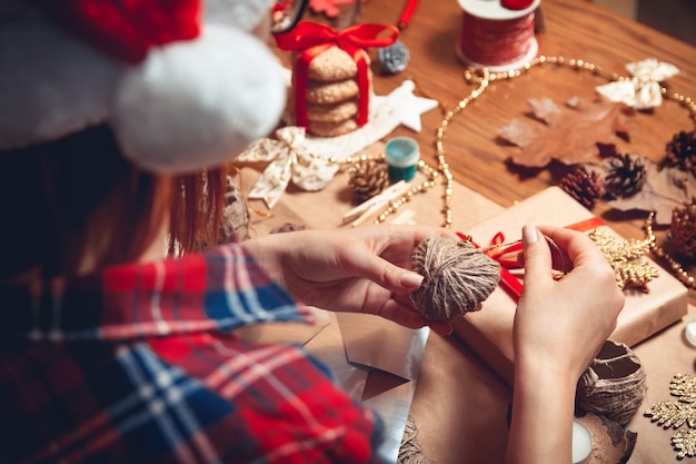 Mão de mulher criando decorações de Natal