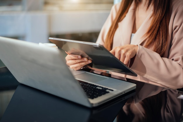 Mão de mulher de negócios trabalhando com um novo computador moderno e escrevendo no diagrama de estratégia do bloco de notas como luz da manhã de conceito