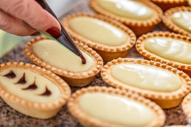 Mão de mulher decorando mini tortas