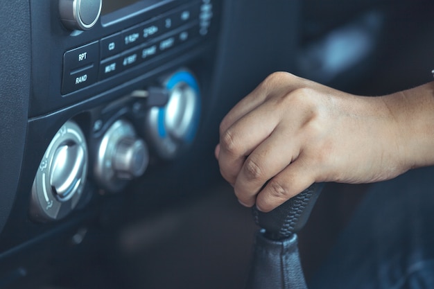 Mão de mulher, deslocando a alavanca de câmbio enquanto estiver dirigindo um carro em tom de cor vintage