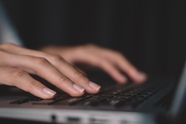 Foto mão de mulher digitando no teclado no local de trabalho empresária trabalhando sobre labtop em uma mesa de madeira fazendo trabalho em casa closeup imagem de mão de trabalho de comunicação empresarial