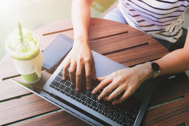 Mão de mulher jovem digitando no laptop para trabalhar no café café