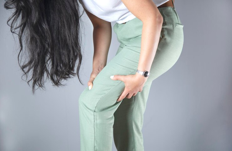 Foto mão de mulher na perna dolorida
