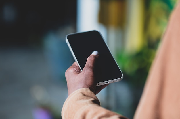 Mão de mulher negra segurando smartphone