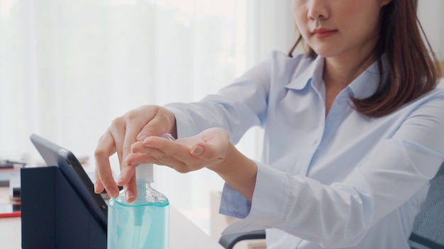 Foto mão de mulher pressionando o gel de álcool da garrafa e aplicar o gel desinfetante para lavar as mãos para limpar e limpar germes, bactérias e vírus. proteção pandêmica, conceito de higiene e cuidados de saúde.