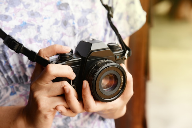 Mão de mulher segurando a câmera retro close-up com espaço de cópia