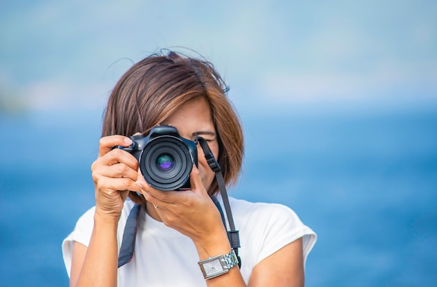 Mão de mulher segurando a câmera Tirar fotos de fundo