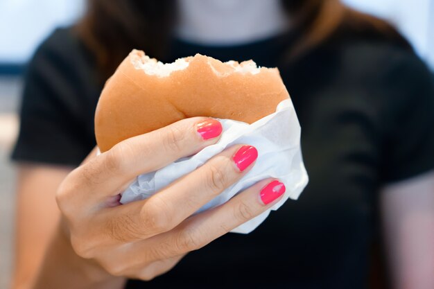 Mão de mulher segurando hambúrguer para fast-food