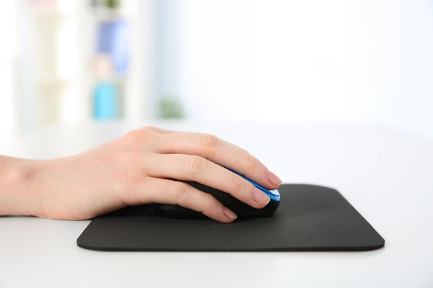 Mão de mulher trabalhando com mouse de computador no escritório