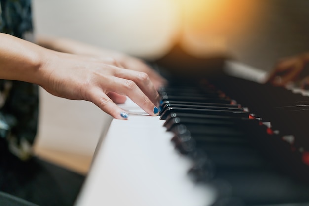 Mão de mulheres no clássico teclado de piano closeup