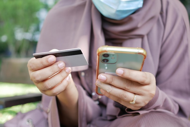 Mão de mulheres segurando cartão de crédito e usando telefone inteligente compras on-line