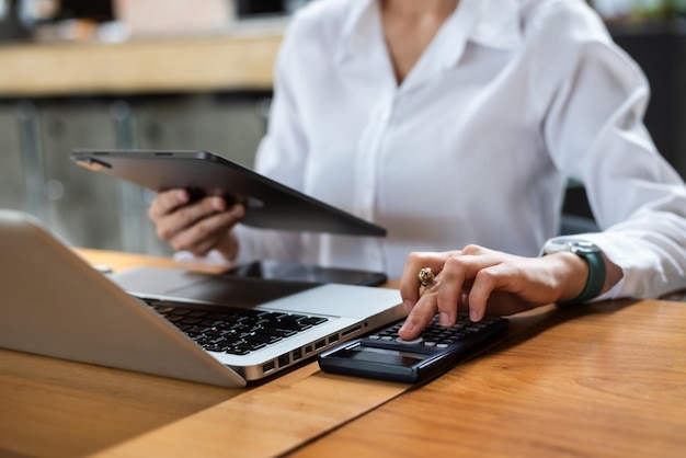 Mão de negócios fazendo finanças e calcular na mesa sobre o custo usando smartphone e tablet como conceptxA