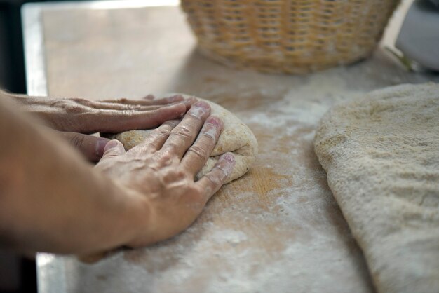 Mão de padeiro moldando pães para assar