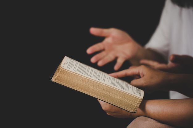 Mão de pessoa jovem segurando a bíblia sagrada com estudo em casa Cristão feminino adulto lendo livro na igreja Menina aprendendo espiritualidade religiosa com rezar a Deus conceito de fé de educação estudantil