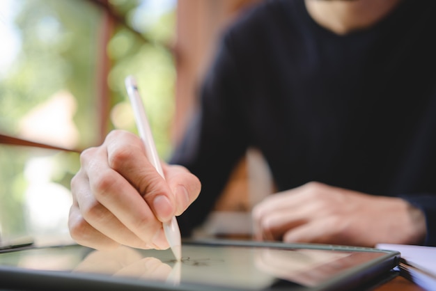 Mão de pessoas segurando uma caneta para trabalhar para escrever em um livro para carta ou documento de negócios, conceito de educação do aluno para aprender usando a página de papel do caderno para anotar um diário em uma mesa de escritório