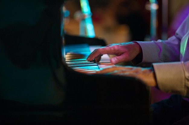 Mão de pianista em um café de jazz - foto com telefoto