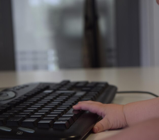 Mão de um bebê com o teclado do computador