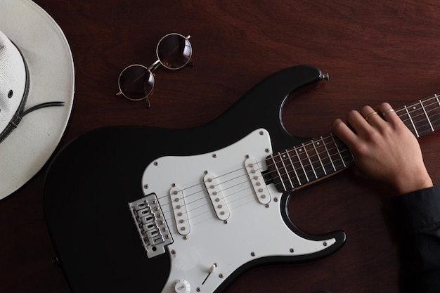 Mão de um guitarrista na guitarra elétrica preta