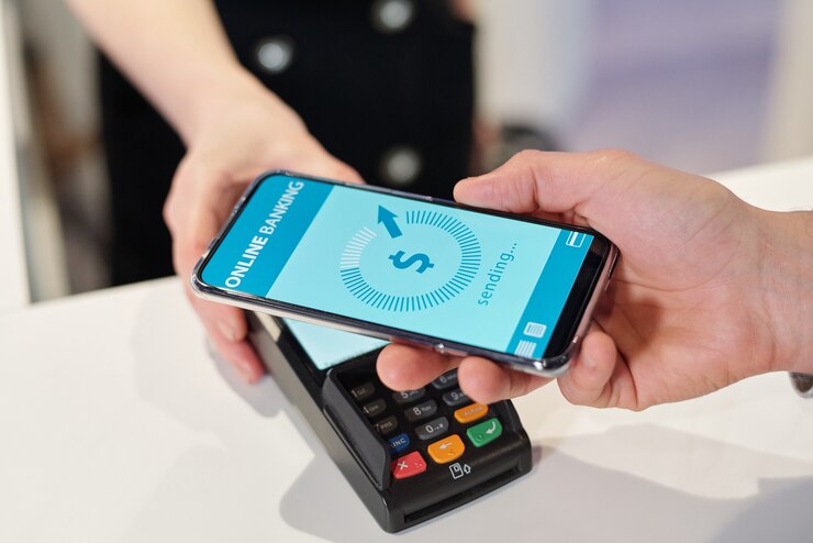 Foto mão de um jovem segurando um smartphone com a página de banco on-line durante o processo de pagamento sem contato em uma loja, supermercado ou centro de lazer