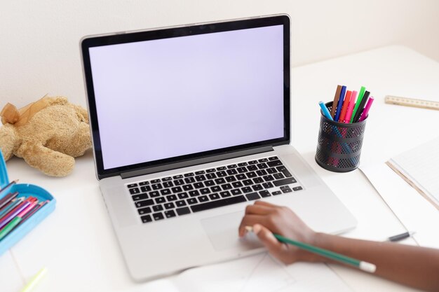 Mão de uma garota afro-americana no quarto usando laptop com espaço de cópia para aula de escola online