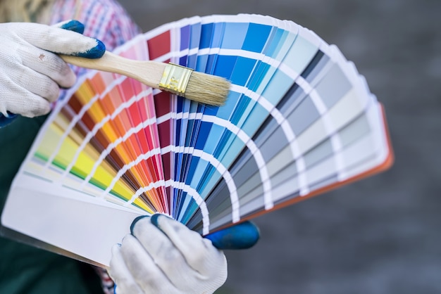 Mão de uma mulher segurando a paleta de cores para reparo. conceito de renovação