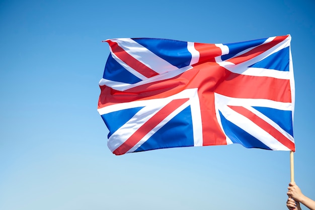 Mão de uma mulher segurando bandeira britânica