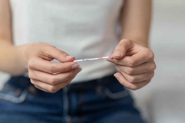 mão de uma mulher segurando o foco seletivo do conceito de cuidados de saúde de teste de gravidez