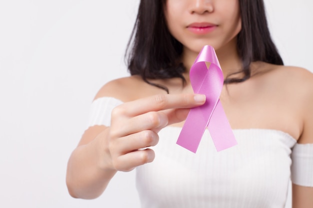 Foto mão de uma mulher segurando o laço de fita violeta, símbolo de conscientização do câncer testicular; fita violeta para conceito médico de arrecadação de fundos de caridade para paciente com câncer testicular ou prevenção de tumor testicular