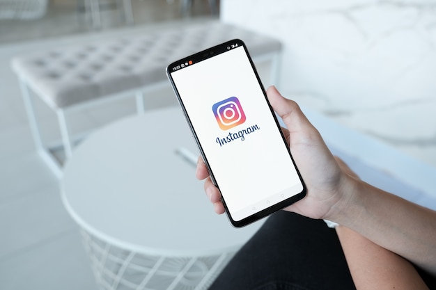 Mão de uma mulher segurando o smartphone com tela de login do aplicativo instagram. instagram é a maior e mais popular rede social de fotos