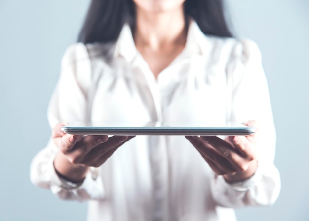 Mão de uma mulher segurando o tablet