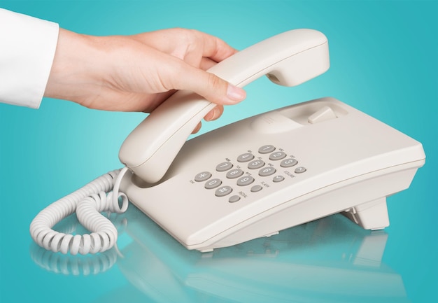 Mão de uma mulher segurando o telefone no fundo desfocado