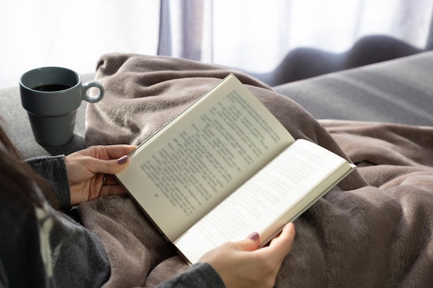 Mão de uma mulher segurando um livro