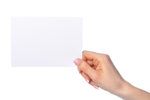 Mão de uma mulher segurando uma folha de papel em branco branca isolada no branco