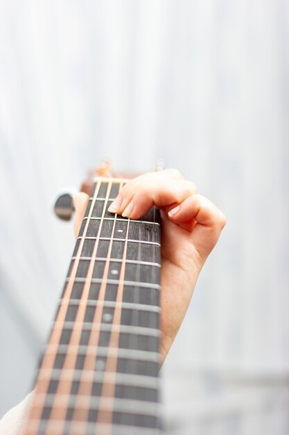 Mão de uma mulher tocando um violão