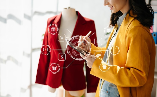 Mão de uma mulher usando um laptop, smartphone e tablet e escrevendo um caderno no escritório doméstico de sua empresa de compras on-line Em casa com o ícone virtual xA