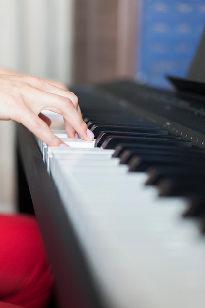 Mão do artista de música clássica tocando piano ou sintetizador eletrônico (teclado de piano)