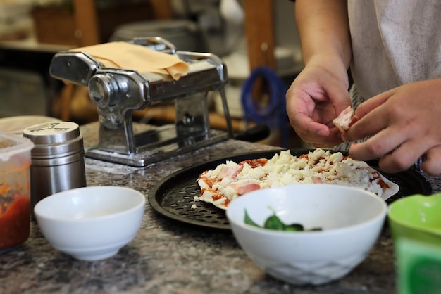 Mão do chef fazendo pizza na cozinha caseira