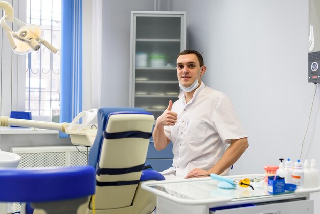 Mão do dentista com um modelo de mandíbula humana O conceito de uma clínica odontológica moderna