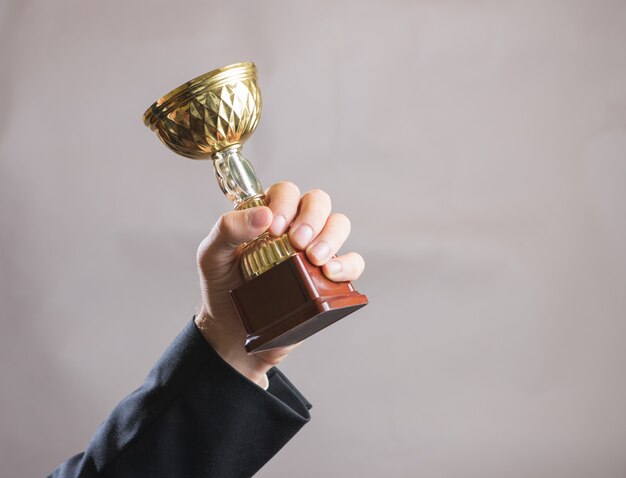 Foto mão do empresário segurando a taça, conceito sucesso