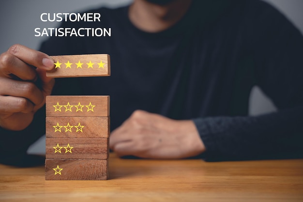 Mão do empresário selecionando bloco de madeira com ícone de 5 estrelas para mostrar excelente satisfação do cliente e feedback positivo para serviços prestados