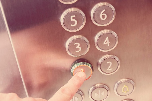 Mão do homem causa primeiro andar no elevador de metal