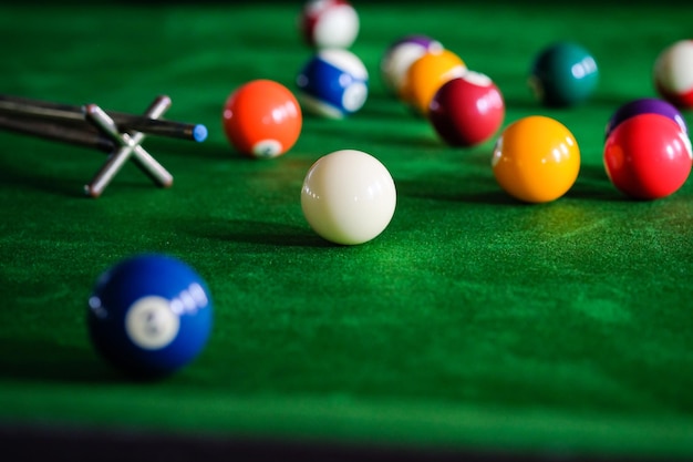 Mão do homem e braço Cue jogando sinuca ou preparando-se para atirar bolas de sinuca em uma mesa de bilhar verde Bolas de sinuca coloridas no friso verde