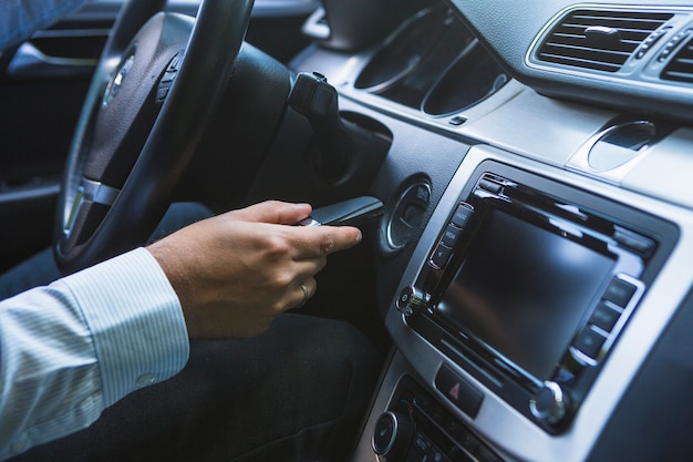 Mão do homem, inserindo a chave para iniciar o carro