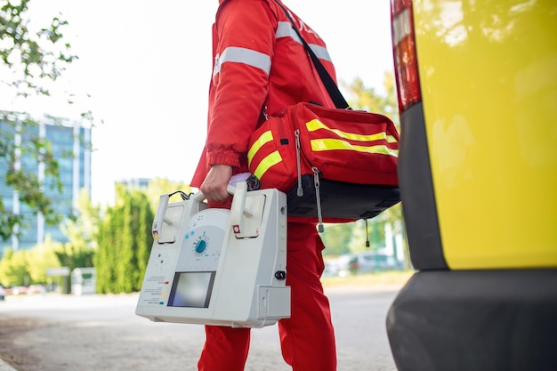 Mão do médico com desfibrilador equipes do serviço médico de emergência estão respondendo a um acidente de trânsito