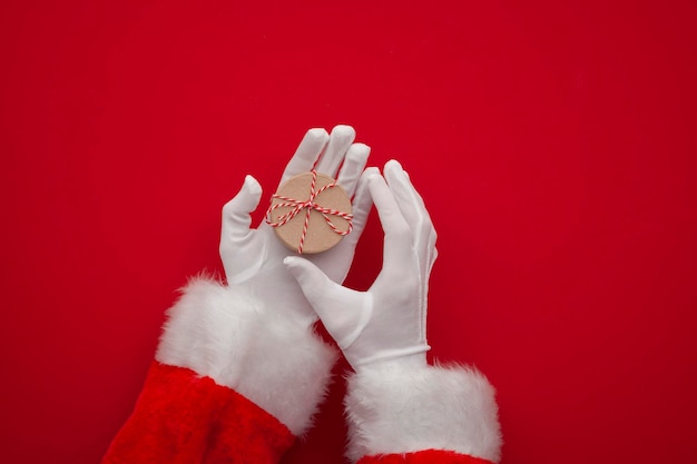 Mão do Papai Noel segurando um presente de Natal