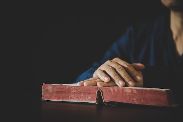 Mão dobrada em oração a deus no livro da Bíblia Sagrada no conceito de igreja para fé espiritualidade e religião mulher pessoa orando na bíblia sagrada na manhã de mulher católica cristã mão com adoração bíblica