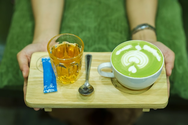 Mão e café e chá verde quente Os jovens adoram beber bebidas quentes.