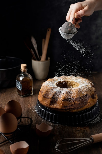 Mão em pó bolo de mármore, mesa de madeira escura