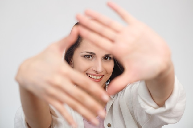 Mão emoldurando retrato de mulher Foco seletivo no rosto